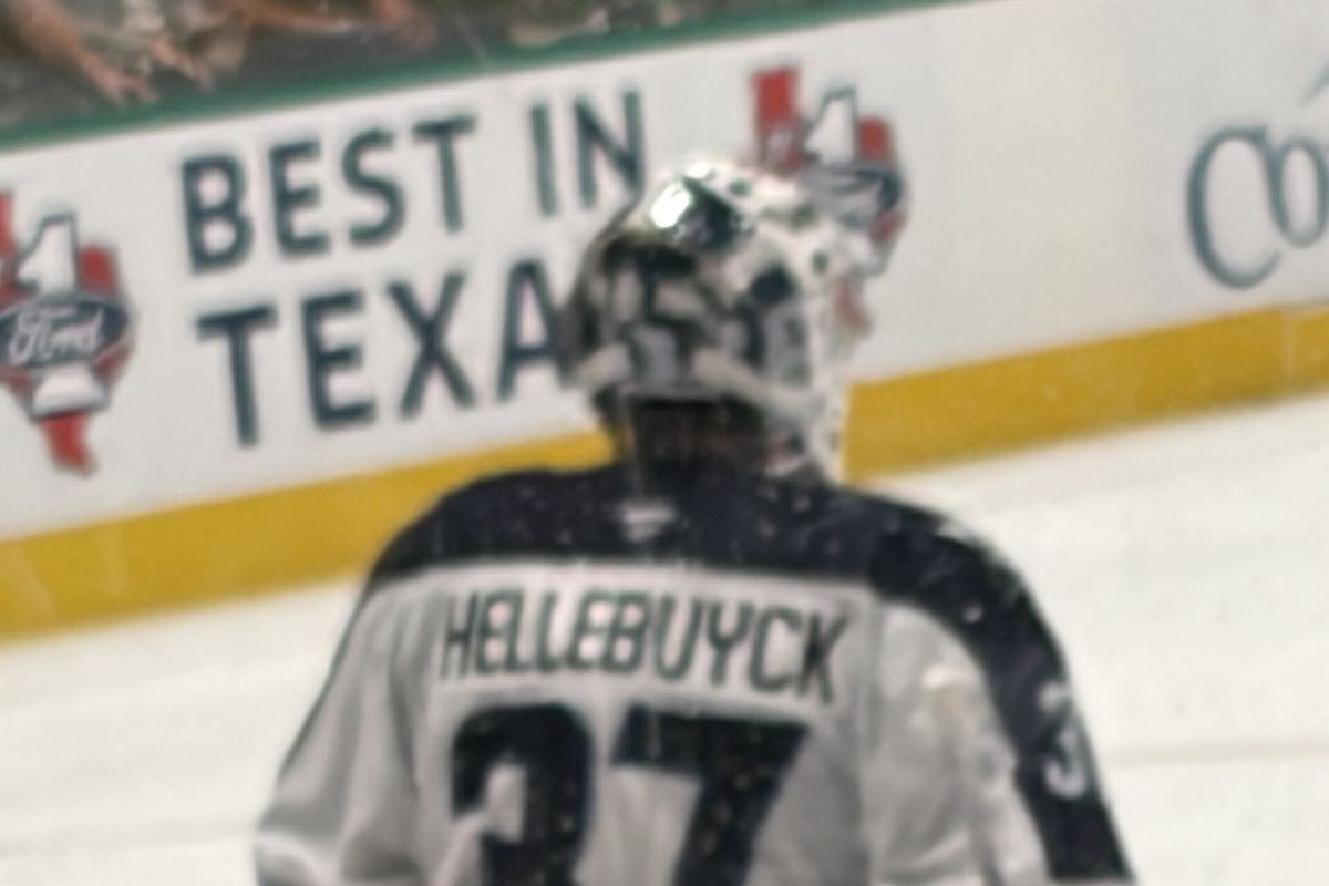 Connor Hellebuyck crouched in his goalie stance in the crease during an NHL game.