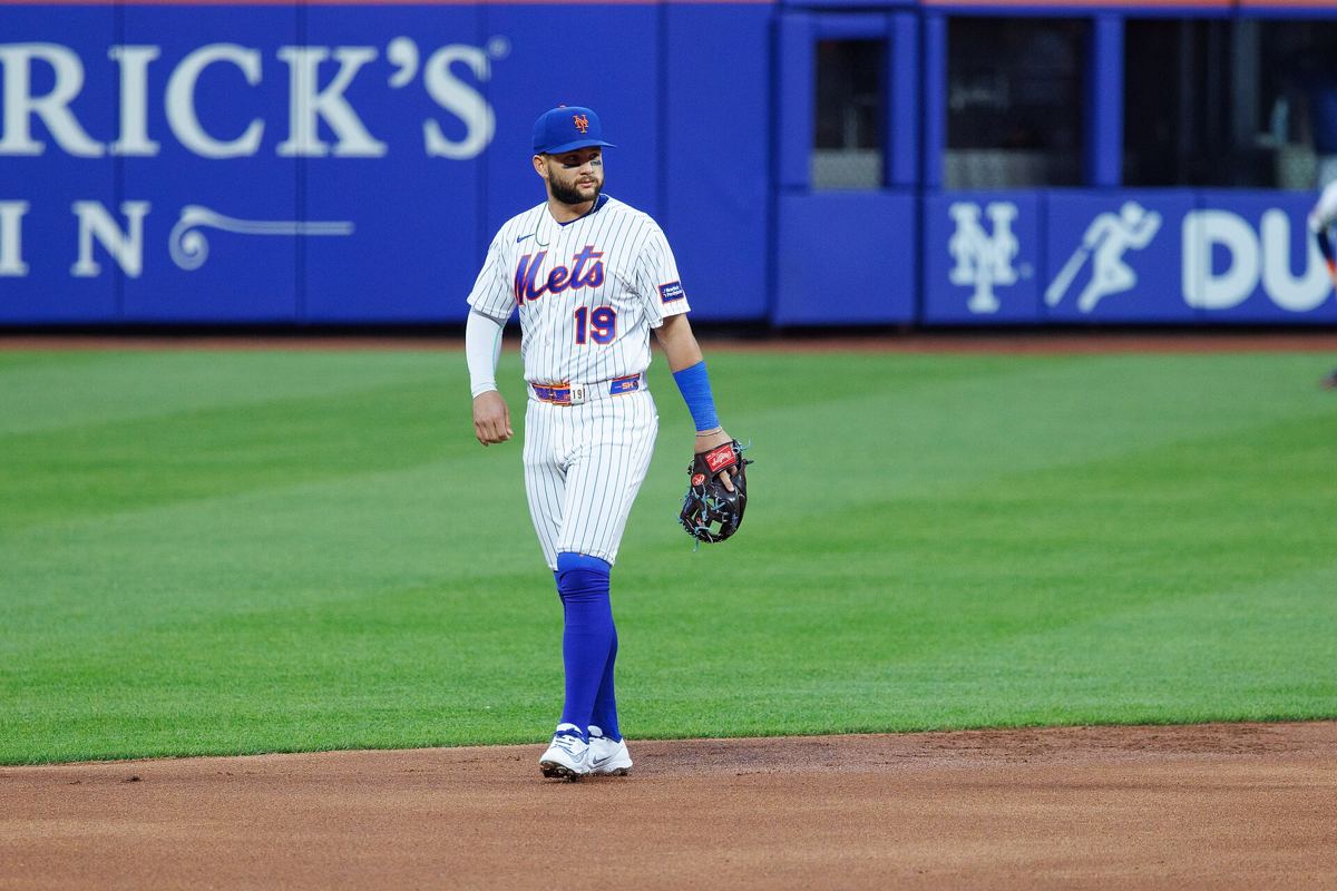 Bo Bichette in a Mets uniform swinging at a pitch during a game.