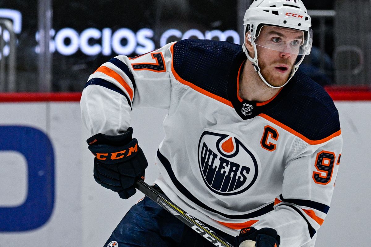 Connor McDavid in an Edmonton Oilers jersey carrying the puck up the ice during a game.