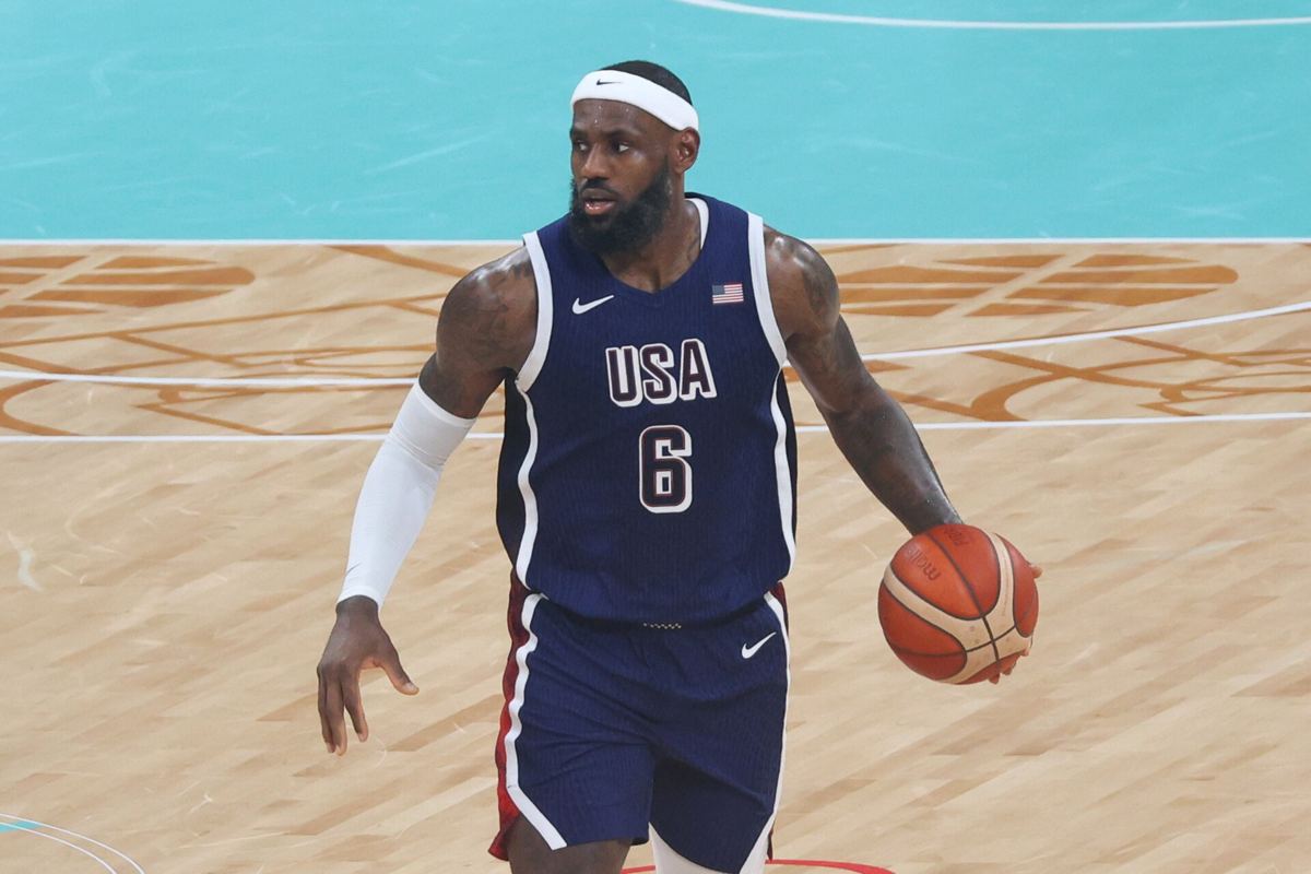 LeBron James in a Philadelphia Sixers uniform bringing the ball up the court during a game.